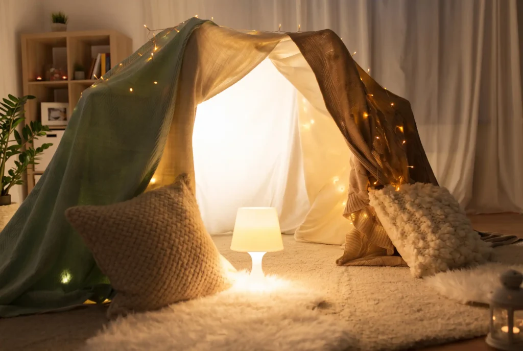 Cosy homemade blanket den with fairy lights for a family evening at home
