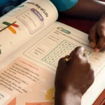 Why Your Maktab Might Benefit From the Quranic Tarbiyah Curriculum 1 Child writing in a Quranic Tarbiyah madrasah curriculum book